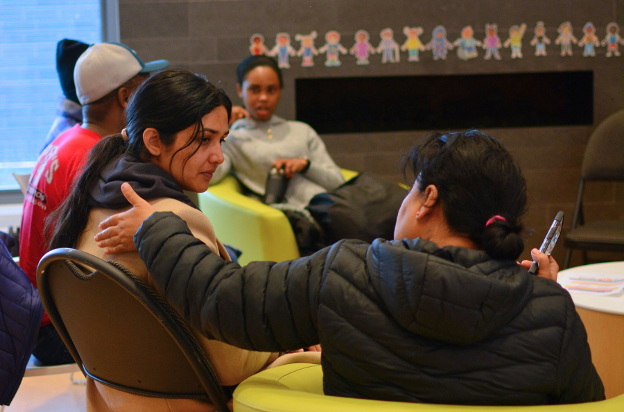 An ErinoakKids mother placing her hand on the shoulder of another mother. 