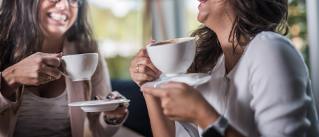 Two women engage in conversation over coffee