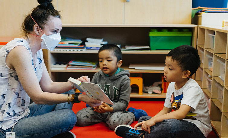 clinician reading book to two children