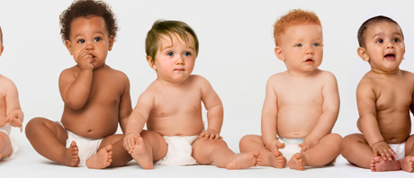 several babies sitting in a row wearing diapers
