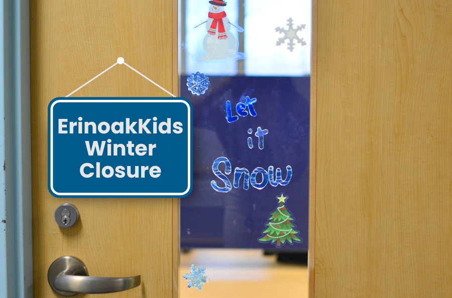 A door with a window that has stickers on it that say "Let it Snow" and a graphic of a sign hanging off of it that has text that reads "ErinoakKids Winter Closure"