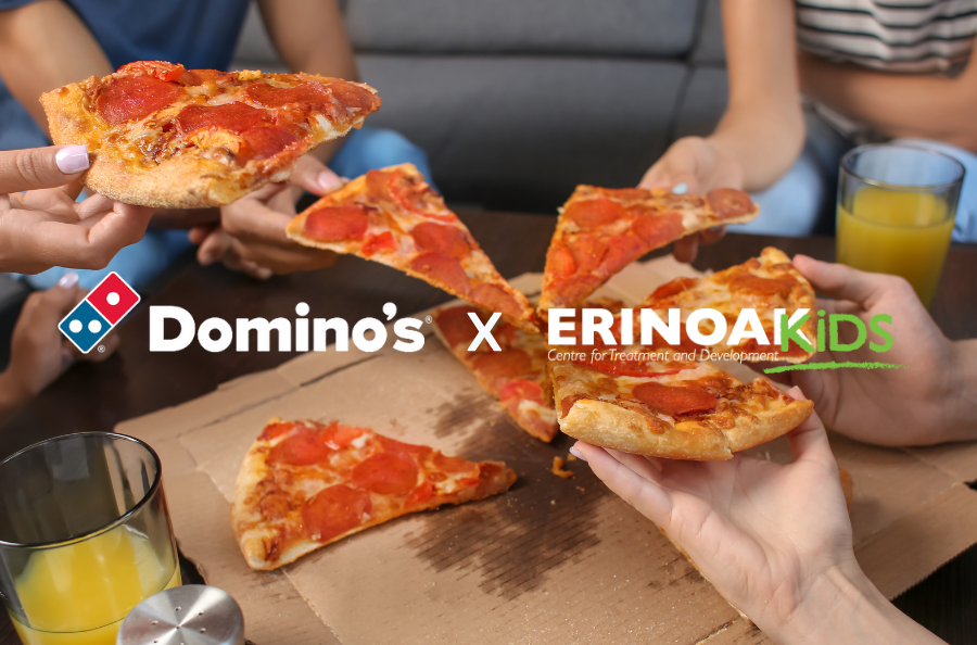 A graphic that reads Dominos (The Dominos pizza logo) x ErinoakKids (ErinoakKids logo) over a photo of people grabbing a slice of pizza