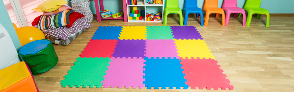 a sensory corner in a classroom with colourful mats, beanbag chairs, and other toys