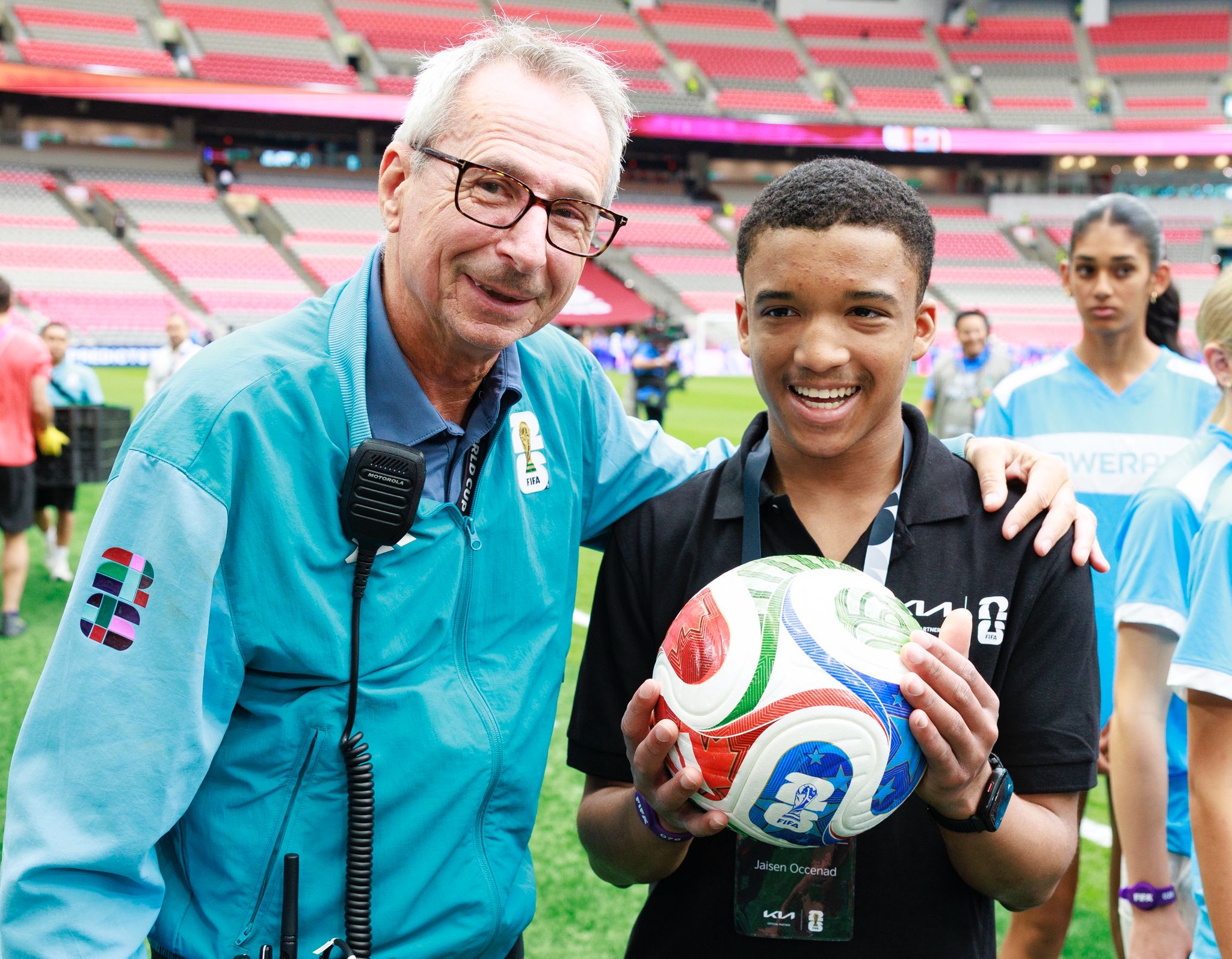 Jaisen holding a FIFA soccer ball and posing with an official
